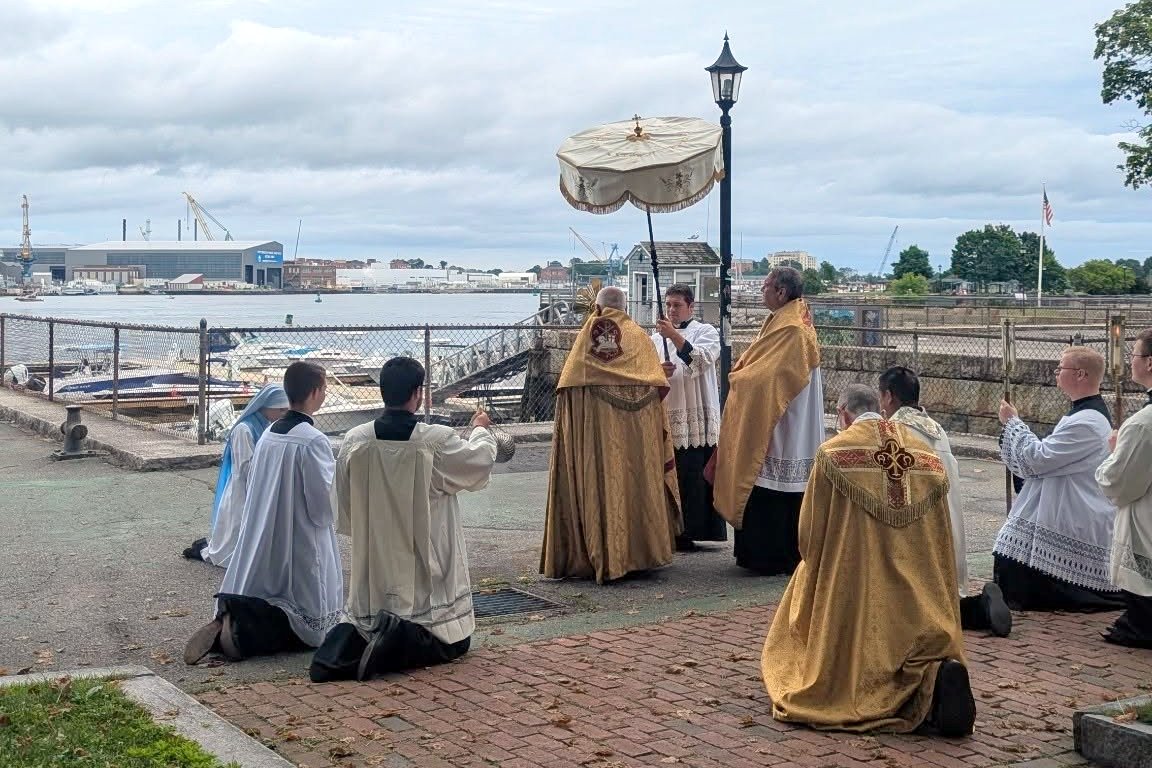 Bishop Libasci prays as Bishop Ruggieri and others kneel.