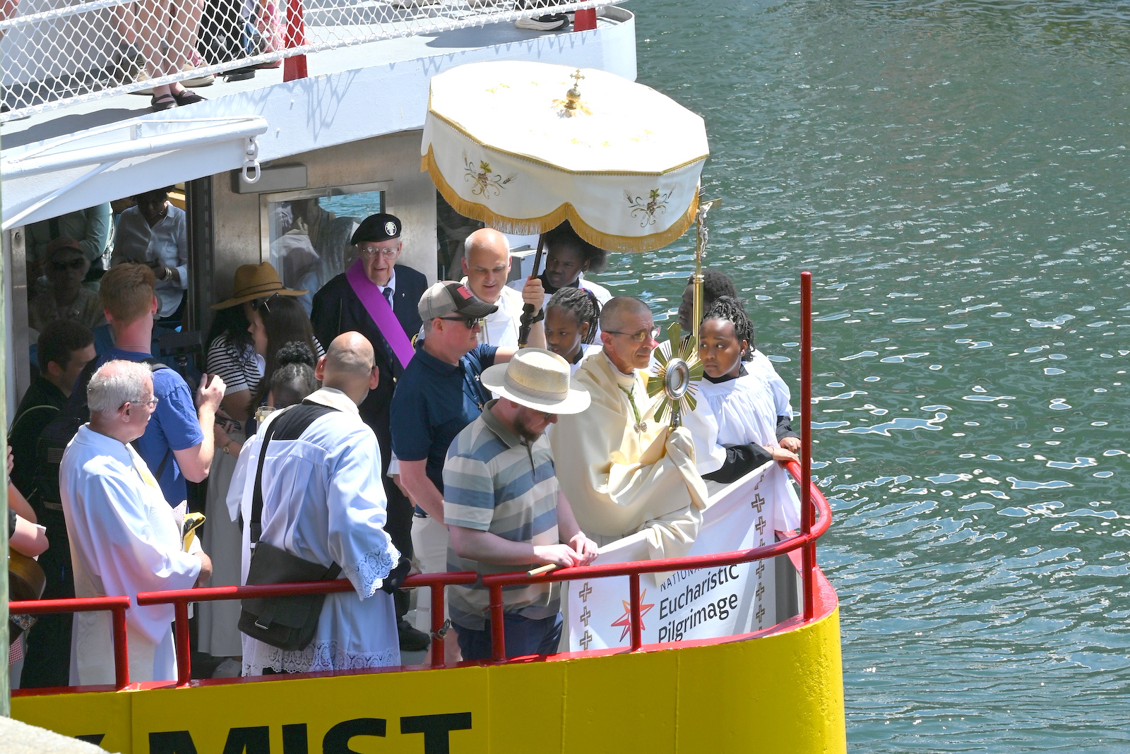 Bishop in bow of ferry carrying monstrance
