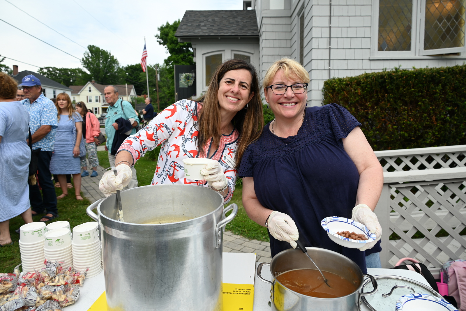 Molly DiLorenzo and friend serve food at cookout.