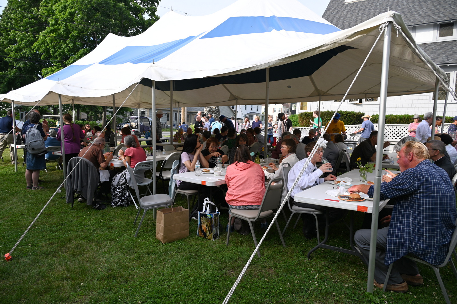 Cookout on Peaks Island - People eating under a tent.