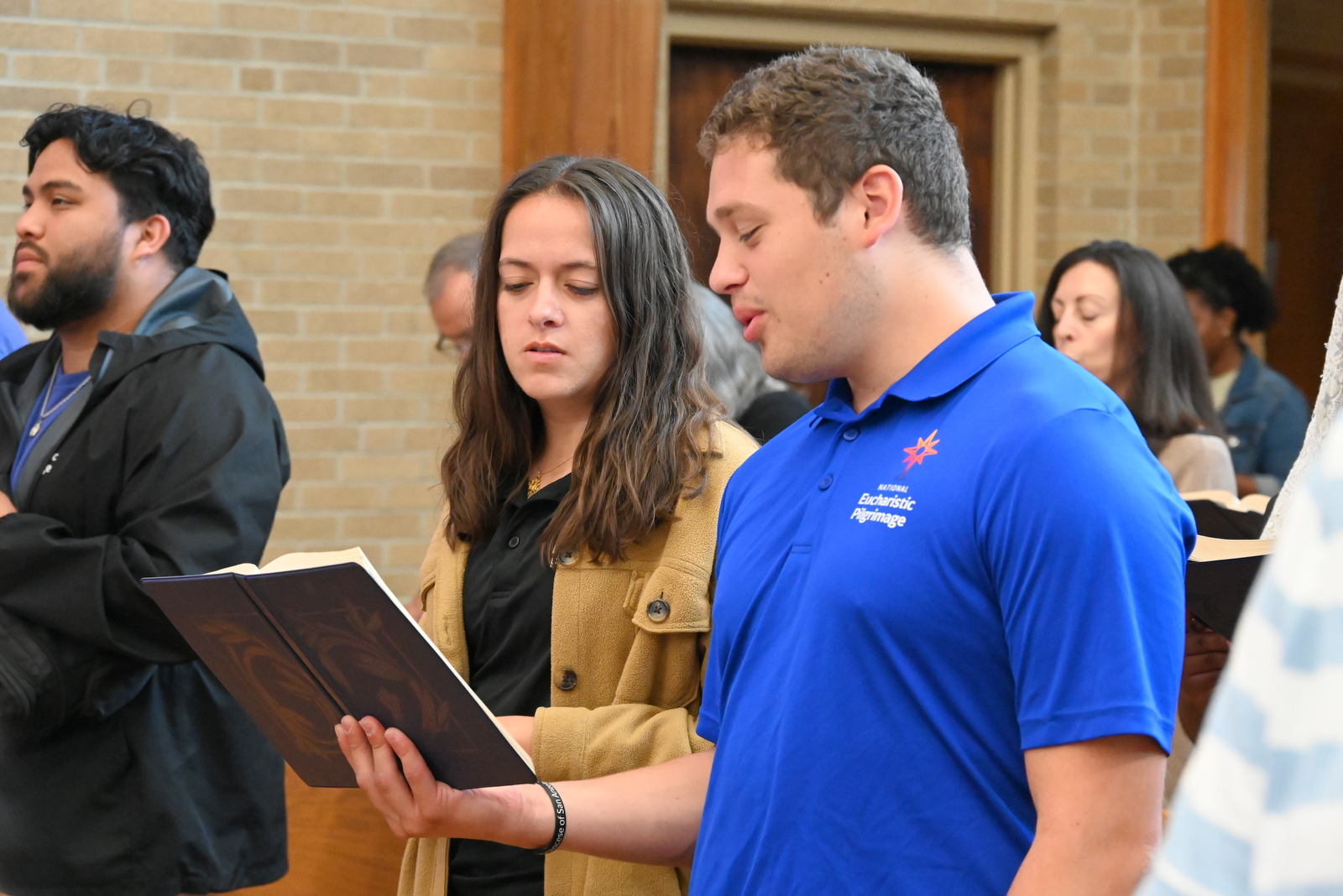 Two of the pilgrims with hymnal in hand.