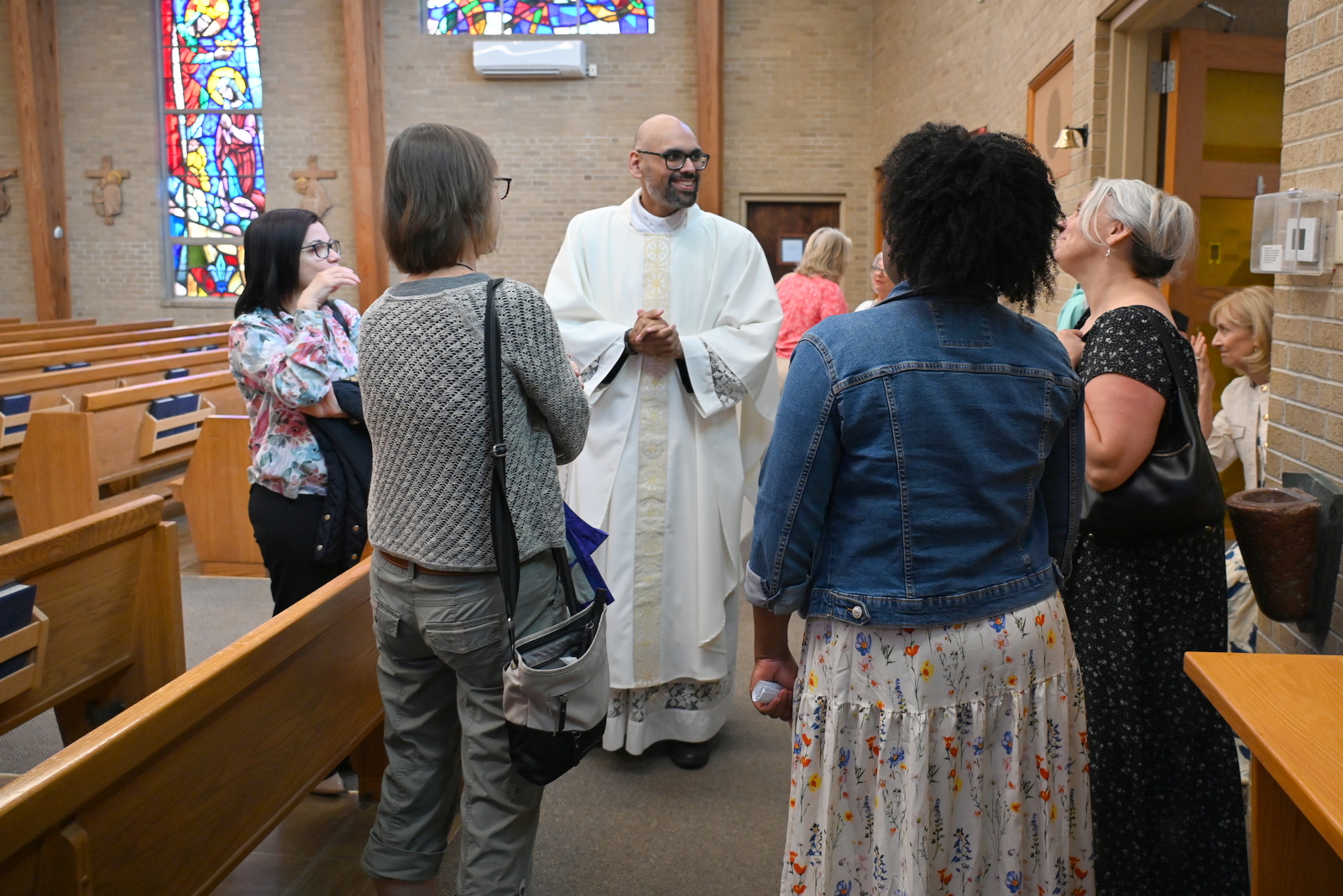 Father Ryan Rojo chats with parishioners after Mass.