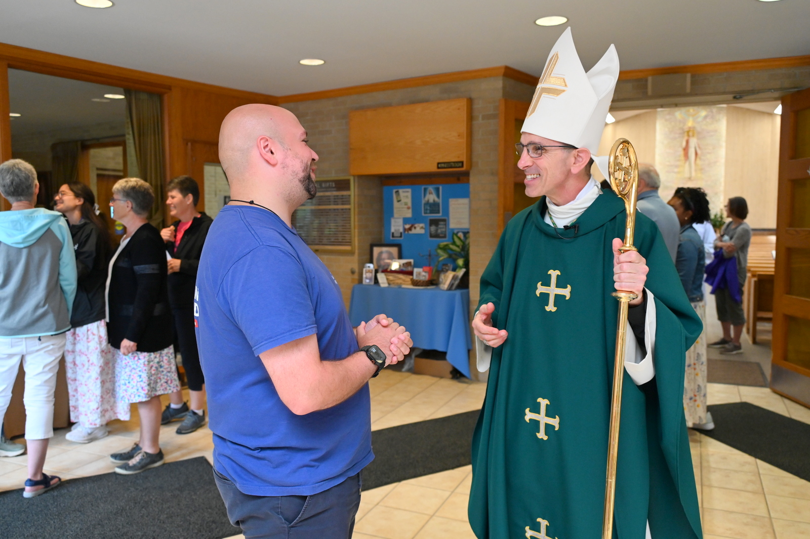 Bishop James Ruggieri chats with one of the pilgrims after Mass.