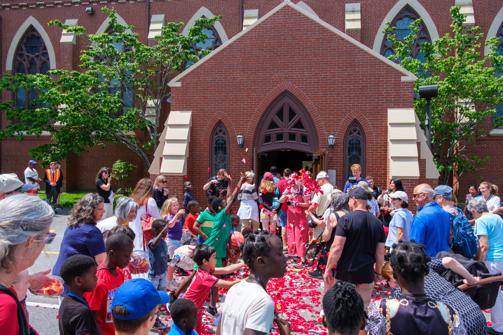 Children throw flower petals as eucharistic procession arrives at the cathedral.