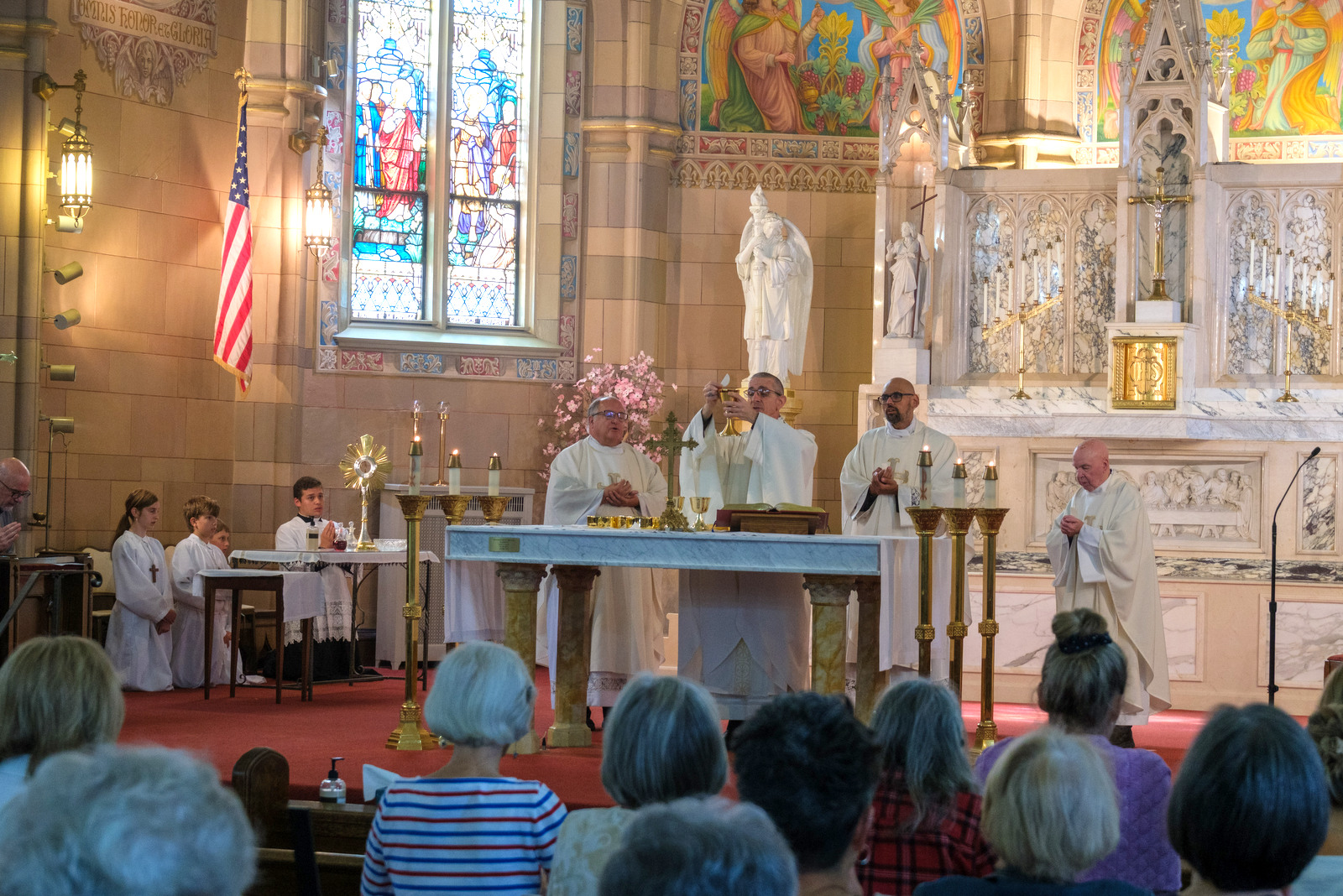 Bishop James Ruggieri holds up the host.