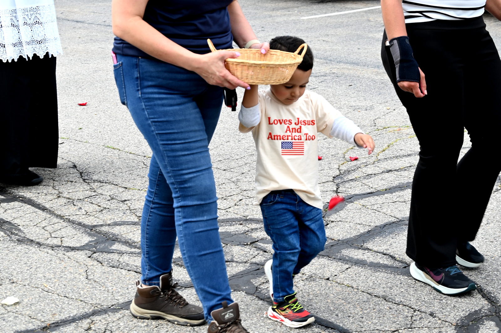 Little boy drops flower petals before the Blessed Sacrament.