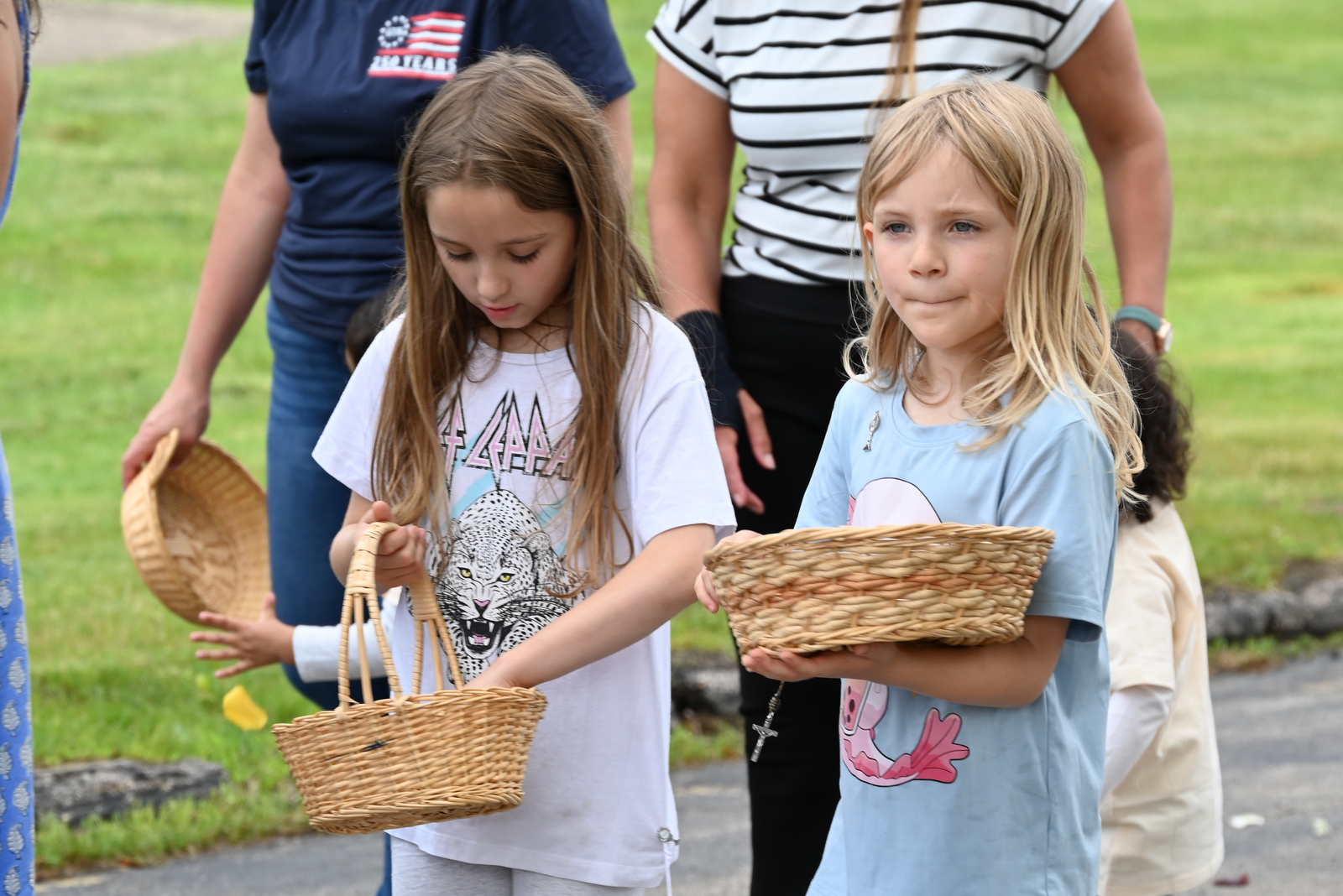 Two girls drop flower petals in the procession.