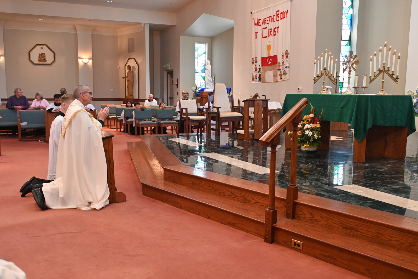 Bishop Ruggieri and an altar server kneel before the Blessed Sacrament.