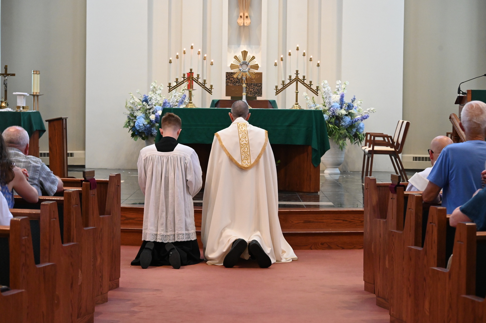 Bishop Ruggieri and an altar server kneel before the Blessed Sacrament.