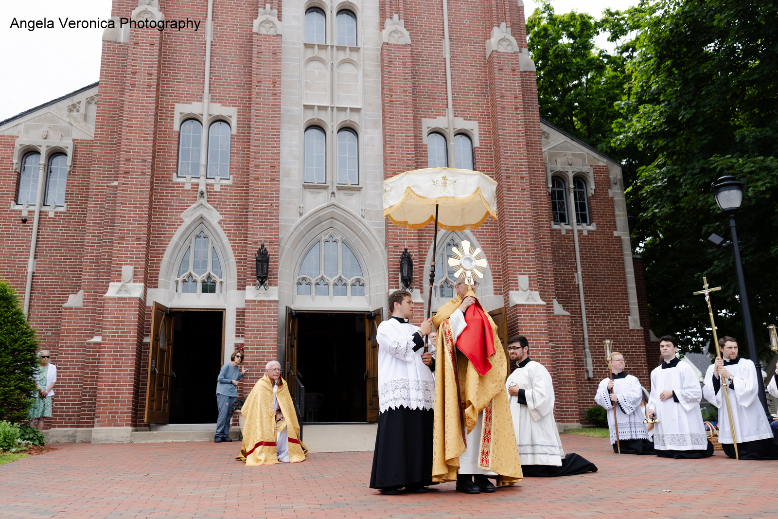 Bishop Ruggieri holding the monstrance with Bishop Libasci kneeling.
