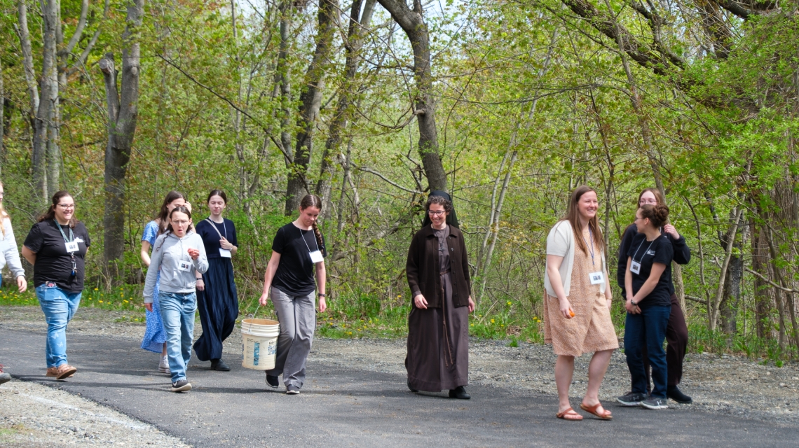a group of young women walking with a Franciscan Sister 