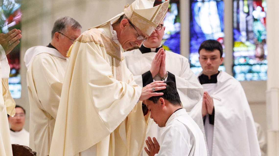 Bishop Ruggieri lays hands on Vinh Nguyen.