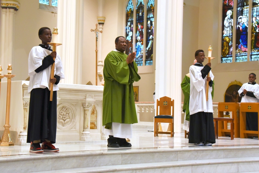 Deacon Michael Augustino and two altar servers await the Book of the Gospels.