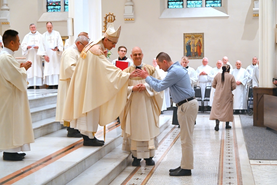 Bishop Ruggieri hands the oils to members of St. Louis Parish in Portland.