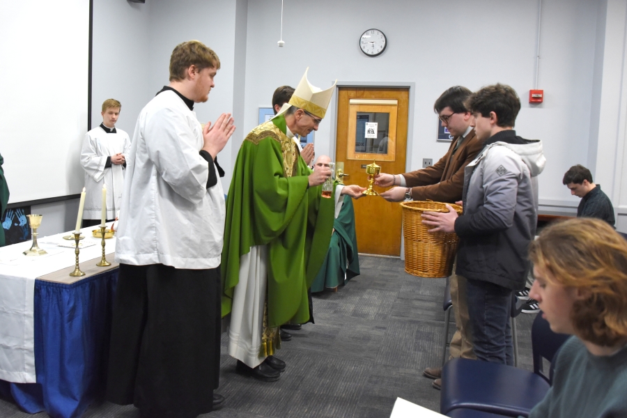 Bishop James Ruggieri accepts the offertory gifts during Mass at UMaine Orono.