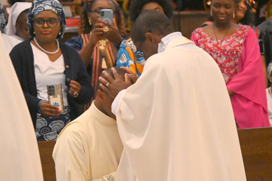 Priest lays hands on Deacon Yisi.