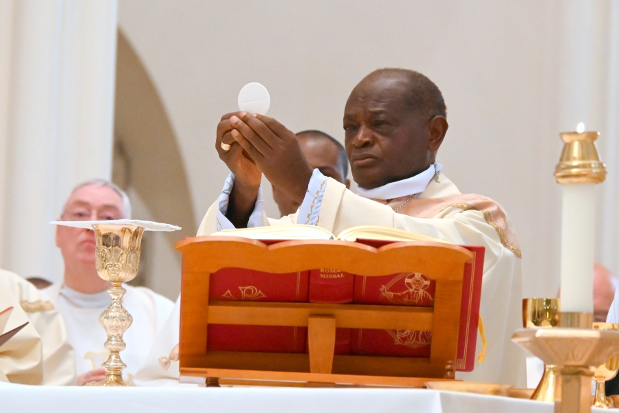 Bishop George Nkuo holds up the host.