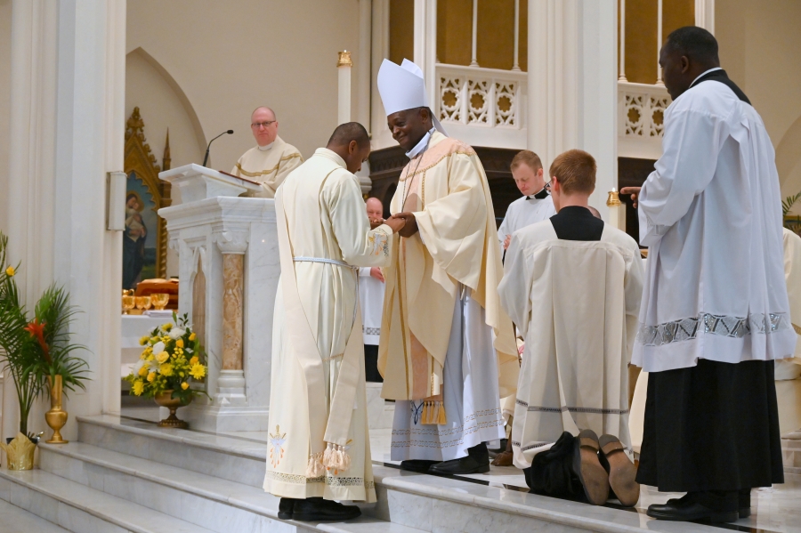 Deacon Yisi stands before BIshop Nkuo