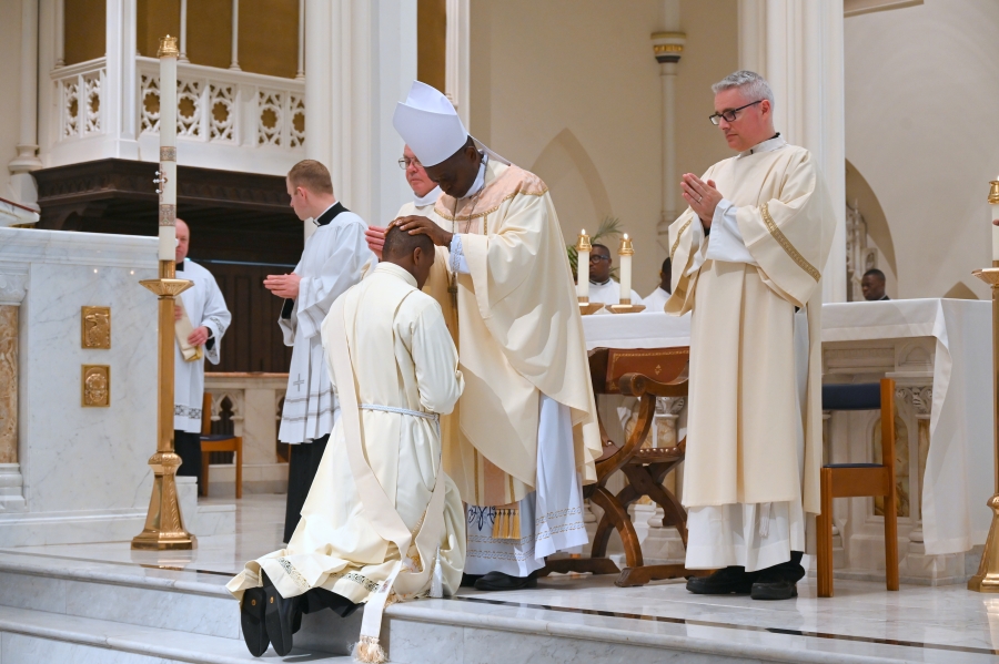 The bishop lays hands on Father Ezekiel Yisi