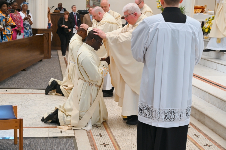 Priests lay hands on the ordinands.