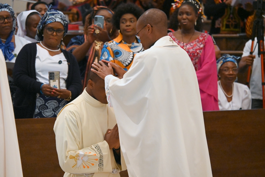 Priests lay hands on the ordinands.