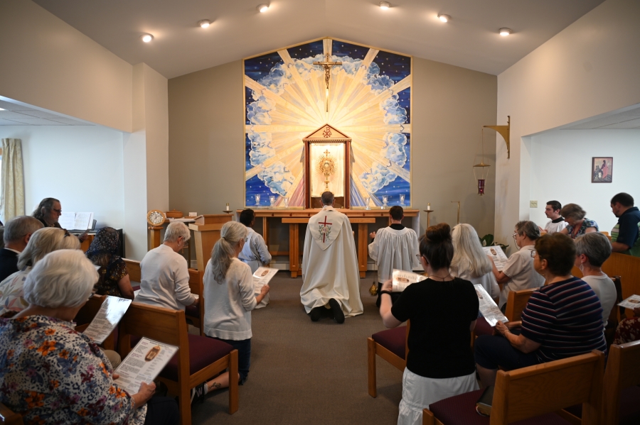 Bishop Ruggieri kneels before the Blessed Sacrament.