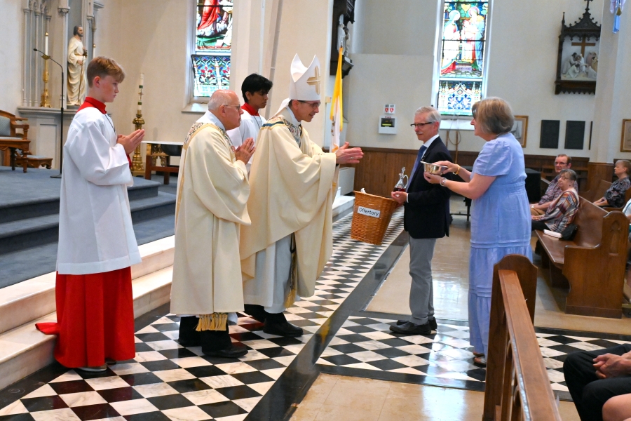 Presentation of gifts to the bishop by a married couple.