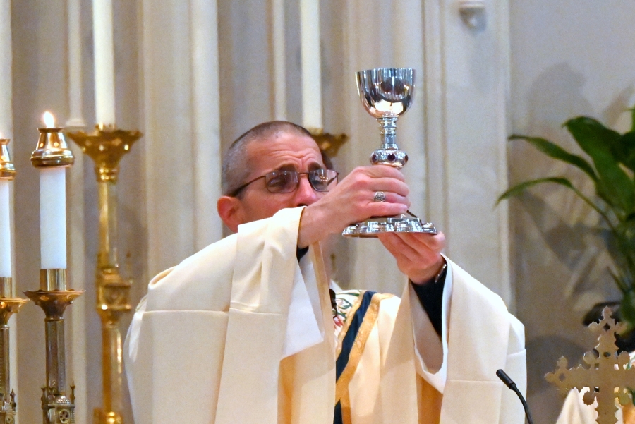 Bishop Ruggieri holds up the chalice containing the Precious Blood.