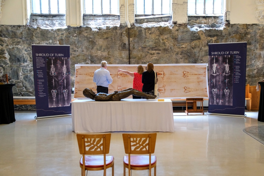 Two people looking at a replica of the Shroud of Turin.