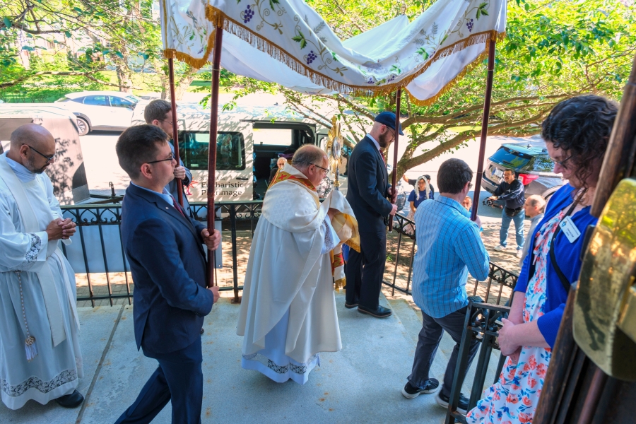 Father Phil Tracy carries the monstrance holding the Blessed Sacrament.
