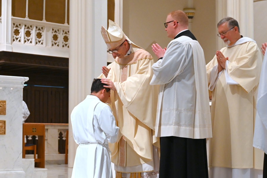 Bishop Ruggieri lays hands on Vinh Nguyen.