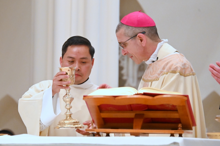 Deacon Nguyen assists the bishop at the altar.