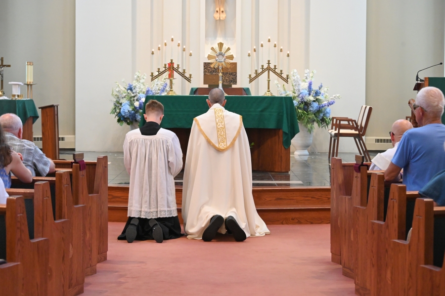 Bishop James Ruggieri kneels before the Blessed Sacrament.