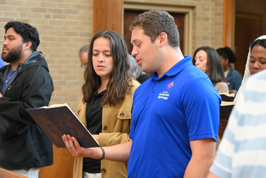 Two of the pilgrims share a hymnal.
