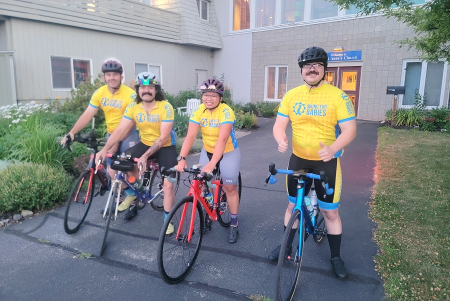 Cyclists wearing yellow shirts and on bikes.