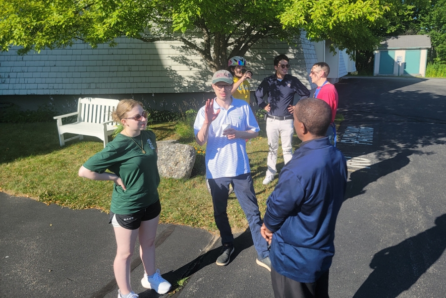 Members of the support team chat with Father Dominic Tumusiime