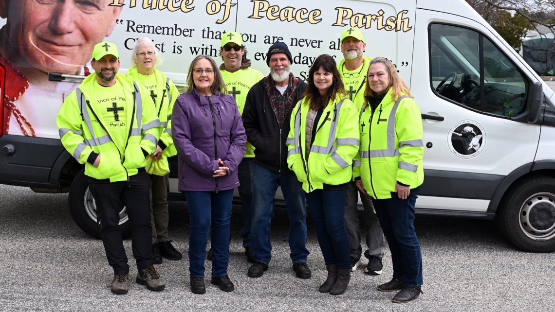 Volunteers with the Cross The Street Ministry standing in front of their food truck