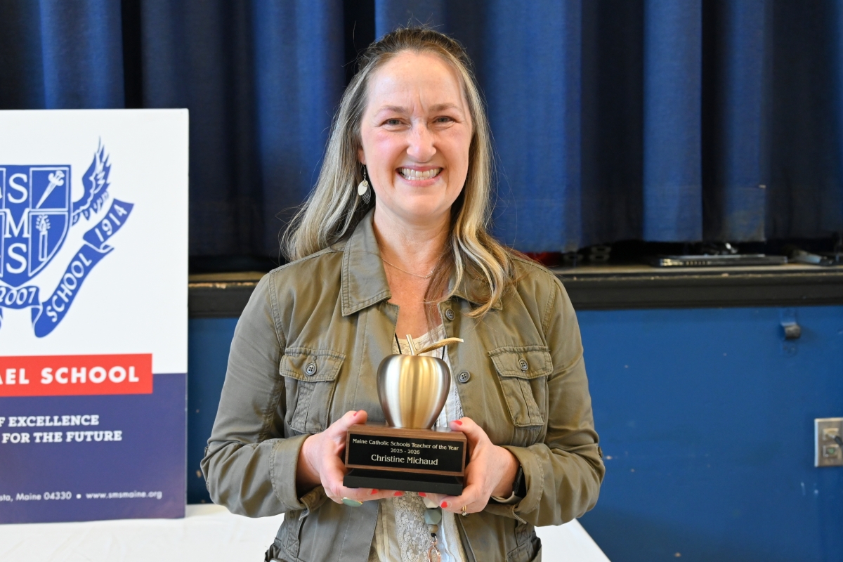 Christine Michaud holding her Teacher of the Year Award.