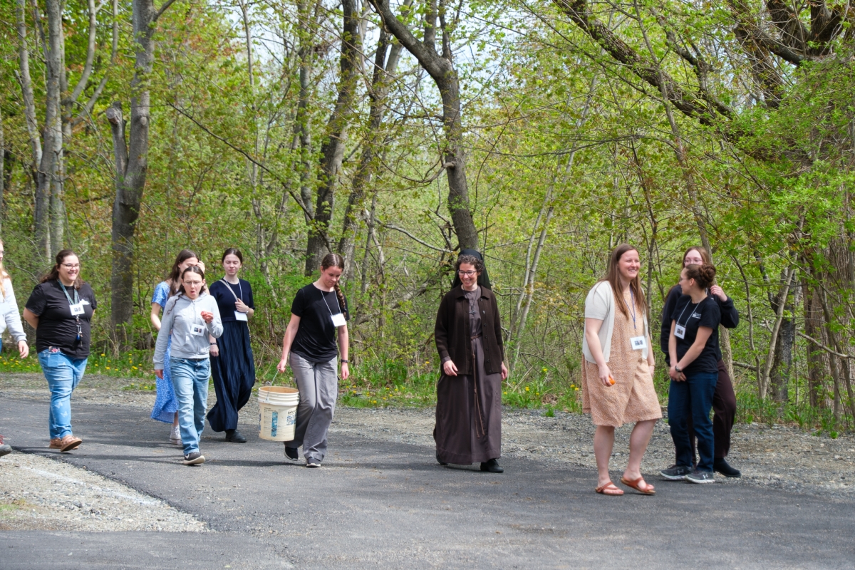 a group of young women walking with a Franciscan Sister 
