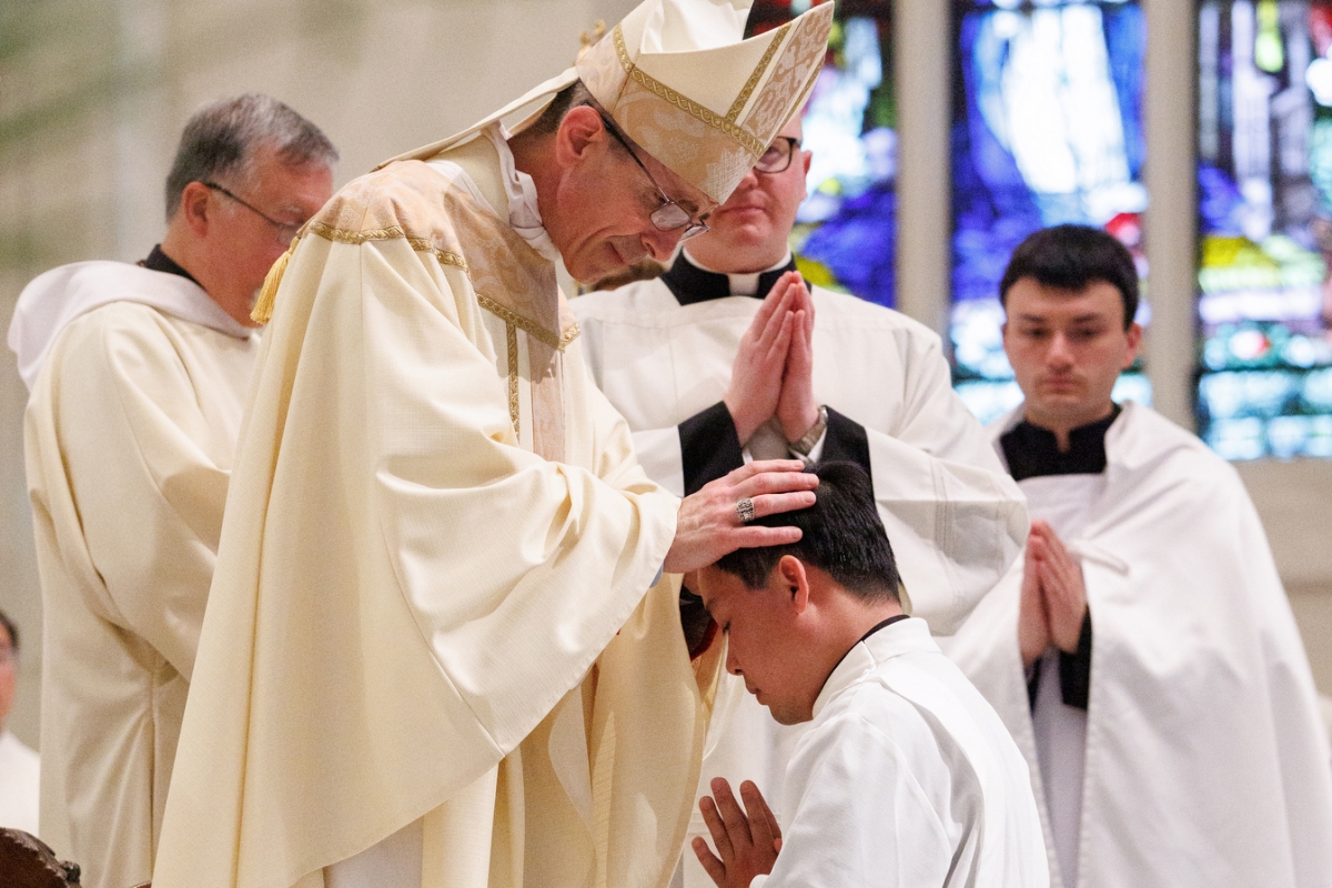 Bishop Ruggieri lays hands on Vinh Nguyen.